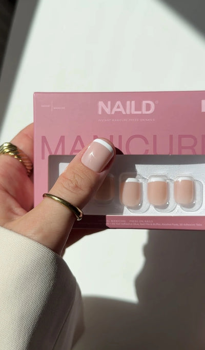 NAILD Fine French XXS Infilled Press-On Nails Verpackung in der Hand – UGC