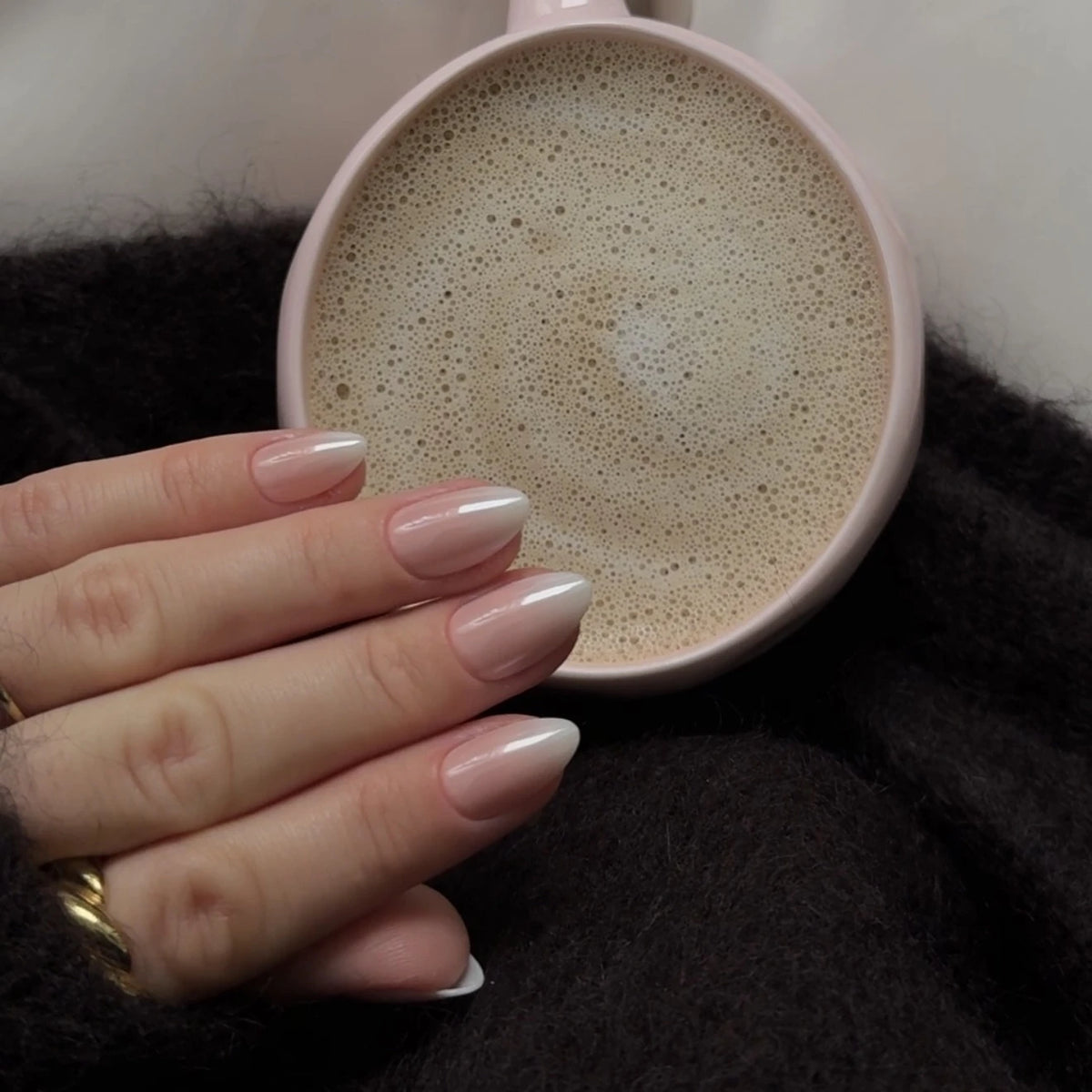 NAILD Milkshake Chrome Almond Press-On Nails getragen mit Kaffeetasse – Lifestyle