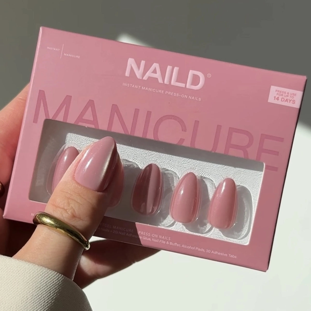 NAILD Sugar Pink Almond Press-On Nails Verpackung in der Hand – Lifestyle
